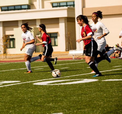 Matthew C. Perry Lady Samurai players attempt to secure the ball from Marist Brothers International School during the Western Japan Athletic Association Girls Soccer Tournament. The team won every single game in the tournament without any team scoring against them, taking home the win for the second year in a row.(U.S. Marine Corps photo by Pfc. Stephen Campbell)