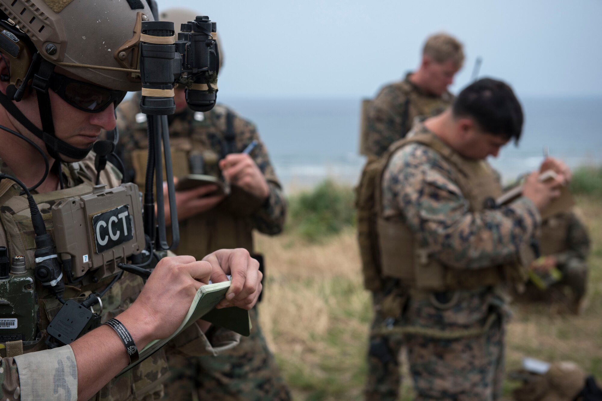 A U.S. Air Force combat control Airman from the 320th Special Tactics Squadron, and U.S. Marine Corps marine joint terminal attack controllers from the 5th Air Naval Gunfire Liaison Company, III Marine Expeditionary Force, coordinate air-to-ground attacks during a training exercise March 10, 2017, at the Irisuna Jima Training Range, Okinawa, Japan. The combat controller and JTAC members coordinated air attacks with B-1B Lancer assigned to the 9th Expeditionary Bomb Squadron and HH-60 Sea Hawks from the Helicopter Sea Combat Unit 12. (U.S. Air Force photo by Senior Airman John Linzmeier)