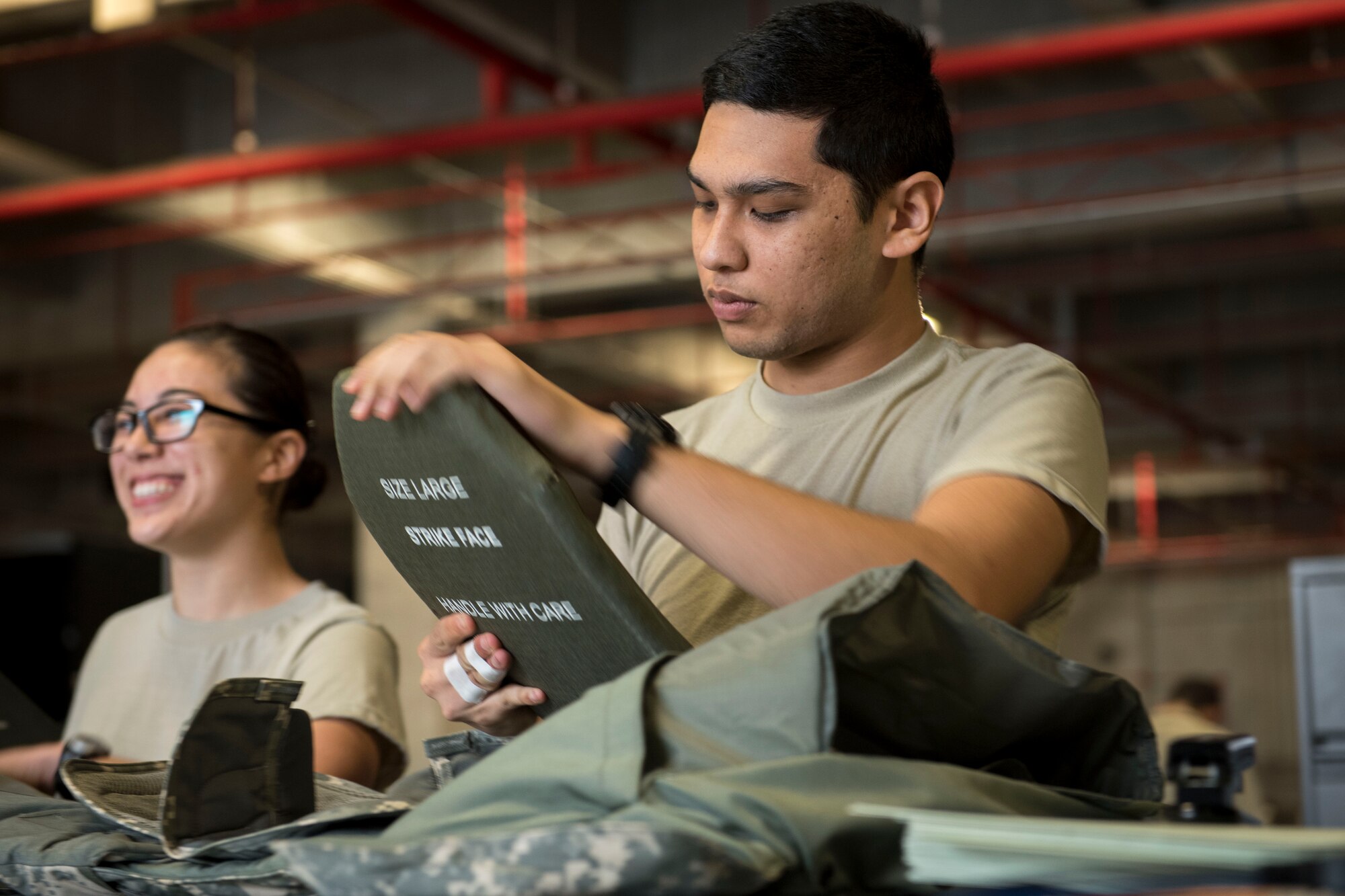 U.S. Air Force Airman 1st Class James Salas, 18th Logistics Readiness Squadron material management technician, inspects a ballistic insert March 13, 2017, at Kadena Air Base, Japan. The IPE Shop is the first line of defense for Airmen, ensuring protective gear is supplied and functions properly. (U.S. Air Force photo by Senior Airman John Linzmeier)
