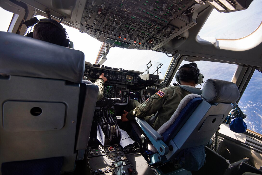 Hawaii Air National Guard pilots fly a C-17 Globemaster III carrying airmen over waters off Joint Base Pearl Harbor-Hickam, Hawaii, March 6, 2017, as they prepare to test new techniques and equipment that will be used to recover the crew module of NASA's Orion spacecraft. Air National Guard photo by Staff Sgt. Christopher Muncy