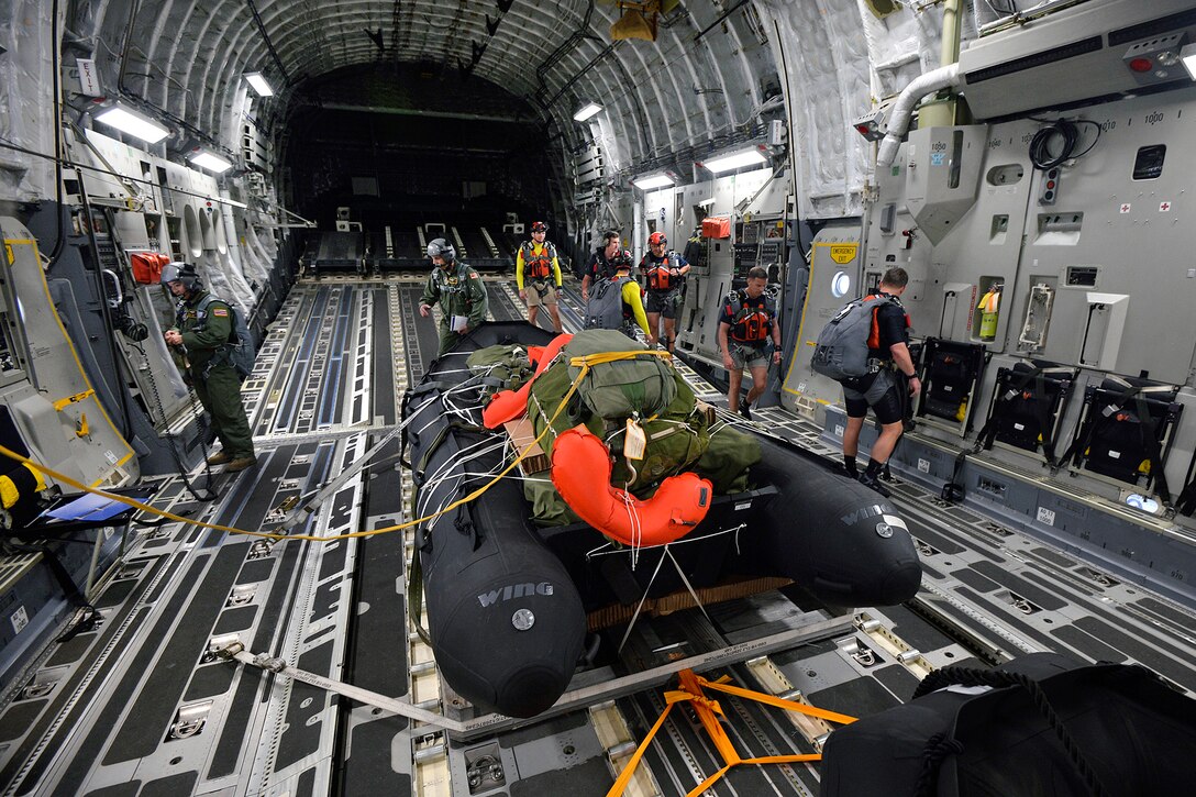New York Air National Guard pararescuemen and combat rescue officers and the crew of a Hawaii Air National Guard C-17 Globemaster III prepare to drop a preloaded inflatable boat into the waters off Joint Base Pearl Harbor-Hickam, March 6, 2017. The airmen were training to test new spacecraft recovery techniques and equipment for NASA. Air National Guard photo by Staff Sgt. Christopher Muncy