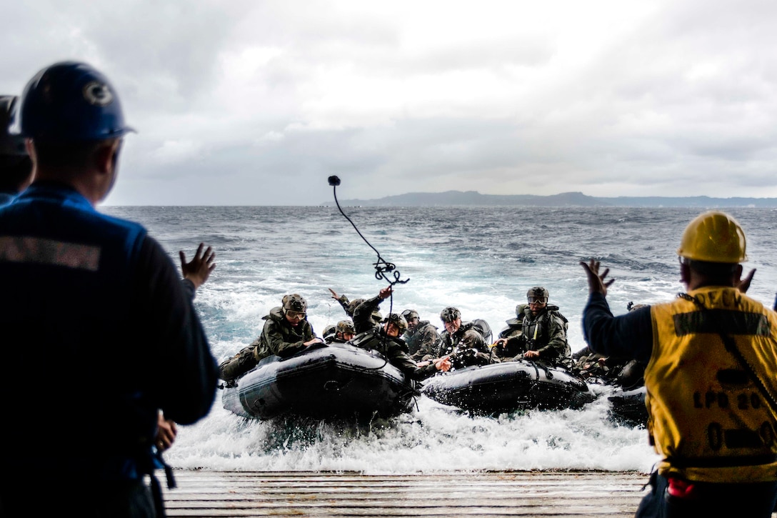 A Marine heaves a line to sailors on the well deck of the amphibious transport dock ship USS Green Bay during combat rubber raiding craft training off the coast of Okinawa, Japan, March 11, 2017. The Marines are assigned to the 31st Marine Expeditionary Unit. The Green Bay, part of the Bonhomme Richard Expeditionary Strike Group, with the embarked Marine unit, is operating in the Indo-Asia-Pacific region to enhance warfighting readiness. Navy photo by Petty Officer 1st Class Chris Williamson