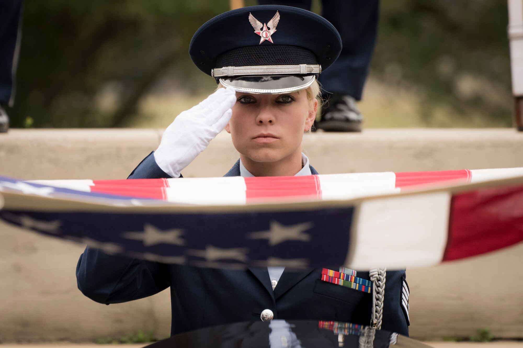Staff Sgt. Elena Konter, 96th Medical Operations Squadron, salutes during the flag-folding portion of the unit’s graduation ceremony at Eglin Air Force Base, Fla., March 1.  Approximately 12 new Airmen graduated from the 120-plus-hour course. The graduation performance includes flag detail, rifle volley, pall bearers and bugler for friends, family and unit commanders. (U.S. Air Force photo/Samuel King Jr.)