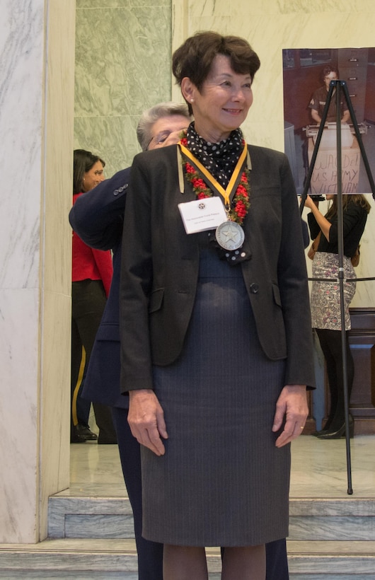 Retired Command Sgt. Maj. Cindy Pritchett places a medal around the Honorable Coral Wong Piesch’s neck as Pietsch is inducted at the U.S. Army Women’s Foundation Hall of Fame Induction ceremony in Washington, D.C., on March 8, 2017.