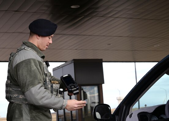 Airman 1st Class Hayden Wilson, a response force member assigned to the 28th Security Forces Squadron, checks an individual to verify their authorization to enter the base at the Liberty Gate on Ellsworth Air Force Base, S.D., March 9, 2017. The new Defense Biometric Identification System 5.0 expedites identifying and vetting personnel requesting base access. (U.S. Air Force photo by Airman Nicolas Z. Erwin)