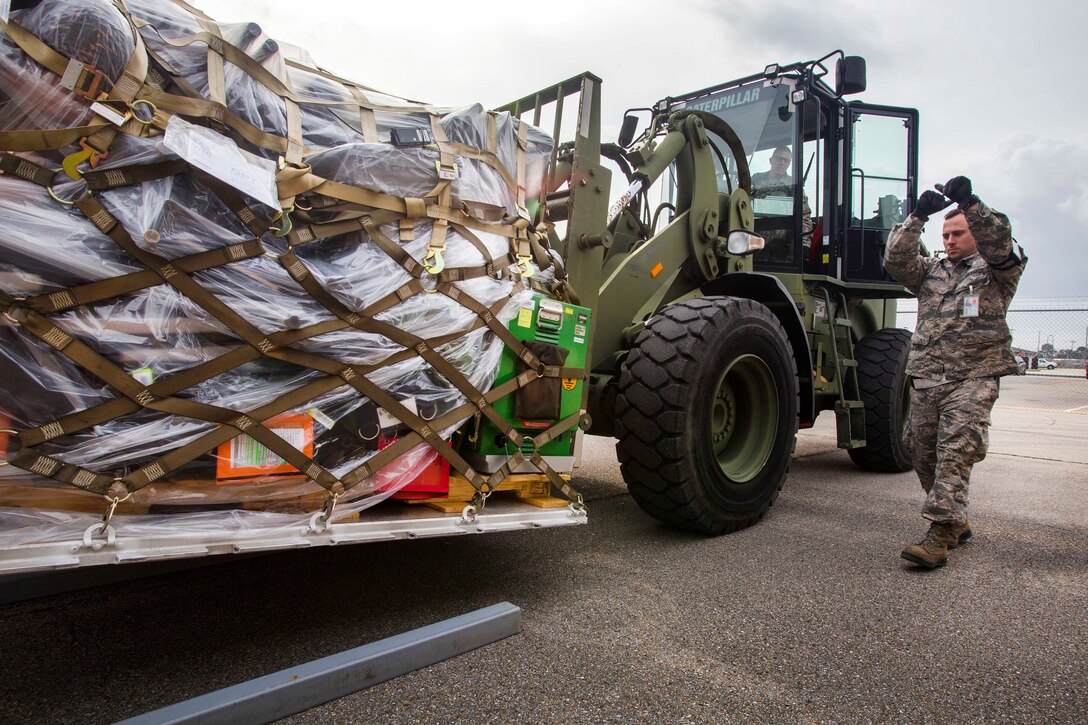 Air Force Master Sgt. Matthew Buonaspina, foreground, directs a loader transferring equipment and supplies during Crisis Response 17 at the Combat Readiness Training Center, Gulfport, Miss., March 5, 2017. Buonaspina is assigned to the 35th Aerial Port Squadron, 514th Air Mobility Wing. Air Force photo by Master Sgt. Mark C. Olsen