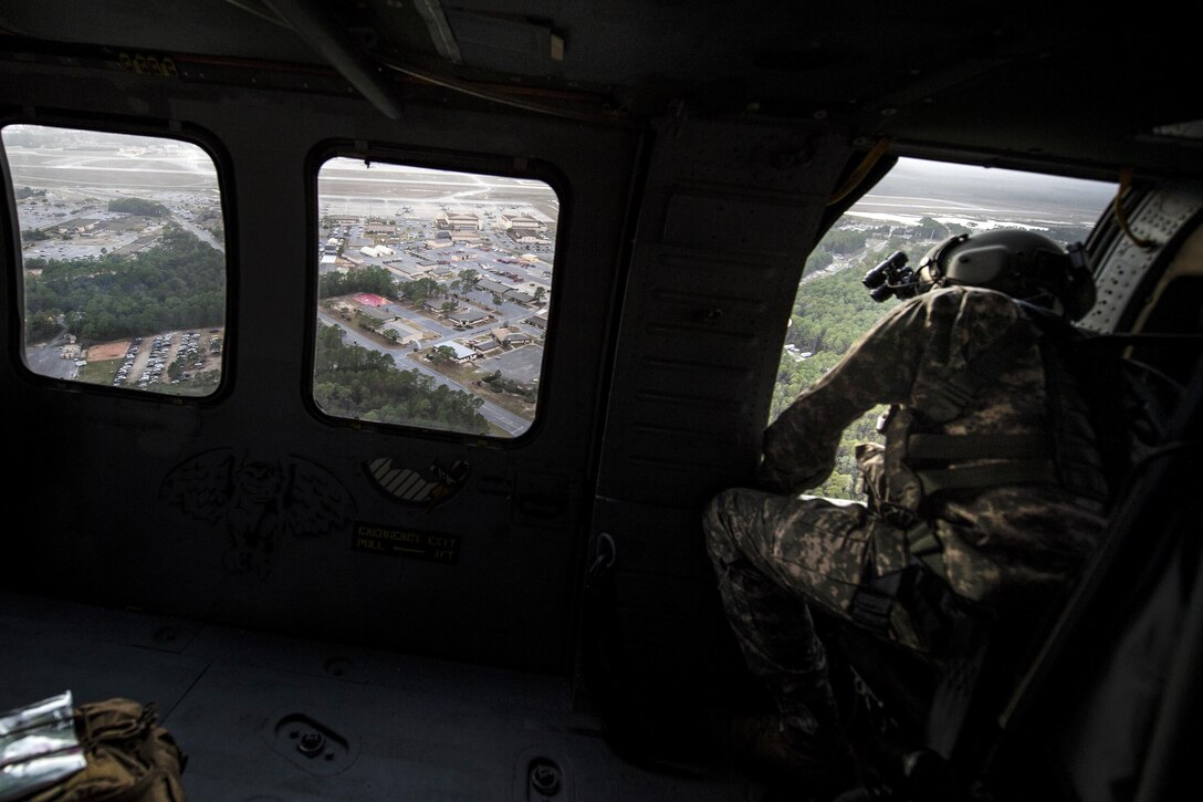 An Army crew chief looks out the window of a UH-60 Black Hawk helicopter for clearance during Emerald Warrior 17 at Hurlburt Field, Fla., March 6, 2017. The crew chief is assigned to the 2nd Battalion, 135th Aviation Regiment. Air Force photo by Staff Sgt. Corey Hook