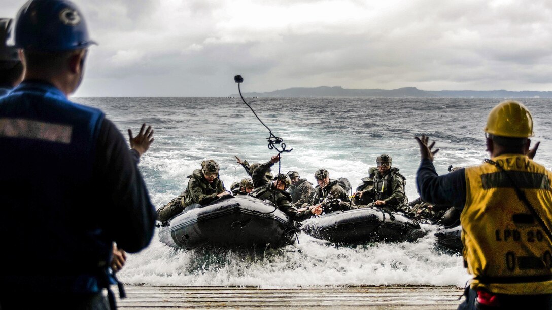 Marine heaves a rope to sailors before arriving at the well deck of the amphibious transport dock ship USS Green Bay during a combat rubber raiding craft rehearsal off the coast of Okinawa, Japan, March 11, 2017. The Marines are assigned to the 31st Marine Expeditionary Unit. The Green Bay, part of the Bonhomme Richard Expeditionary Strike Group, with the embarked Marine unit, is operating in the Indo-Asia-Pacific region to enhance warfighting readiness. Navy photo by Petty Officer 1st Class Chris Williamson