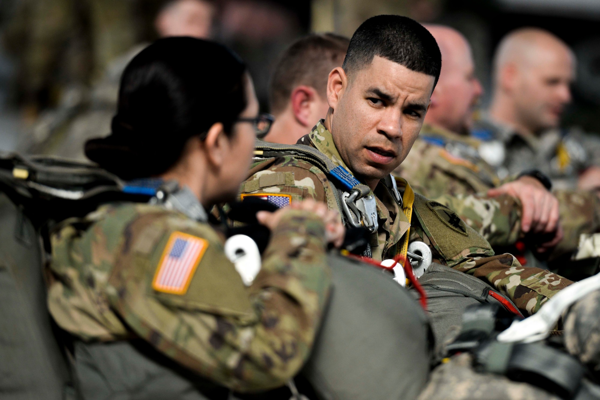 U.S. Army Reserve Staff Sgt. Marcos Moura, 360th Civil Affairs Brigade civil affairs specialist, talks with Master Sgt. Paloma Rodgers, 360th CA Brigade human resource specialist, while they wait to conduct a jump at Wright-Patterson Air Force Base, Ohio, as part of a joint service training exercise, March 11, 2017. The 412th Civil Affairs Battalion (Airborne) mobilizes, deploys, plans and conducts civil affairs operations with an orientation to the theater commander. (U.S. Air Force photo by Wesley Farnsworth / Released)