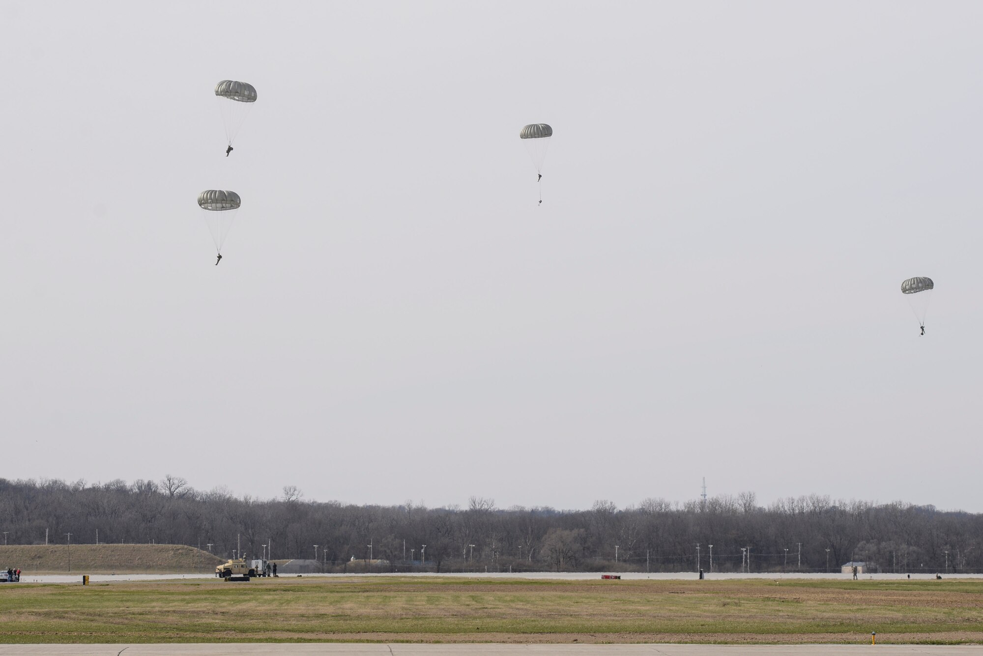 Soldiers with the 412th Civil Affairs Battalion and 346th Psychological Operations Company, based in Whitehall, Ohio, descend to a drop zone established on the flightline of Wright-Patterson Air Force Base, Ohio, March 11, 2017. The soldiers were participating in a joint service training exercise including both day and night jump operations.  (U.S. Air Force photo by Wesley Farnsworth / Released)