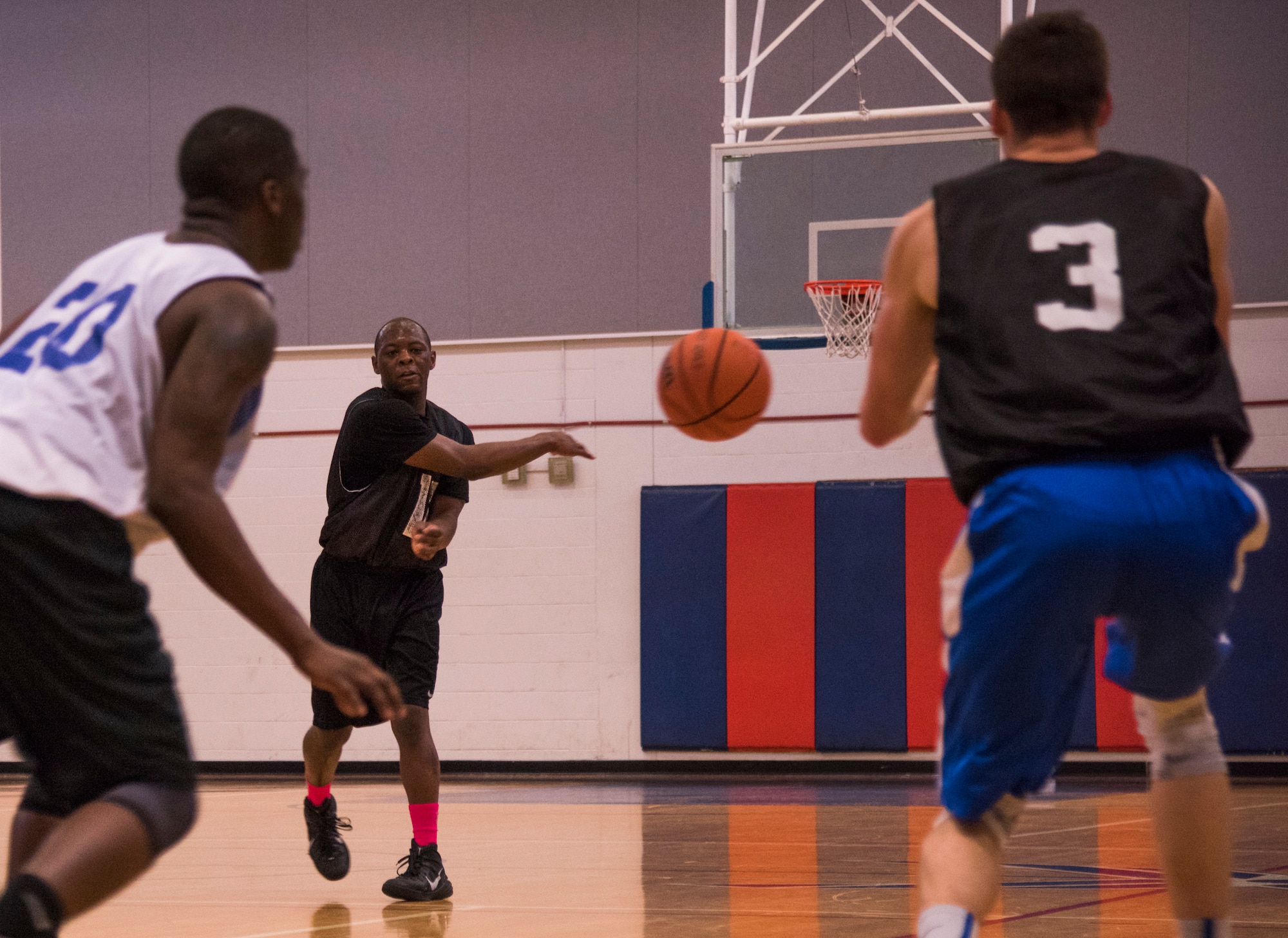 An Armament Directorate competitor passes the ball to David Adler during the intramural basketball championship March 6 at Eglin Air Force Base Fla. The EB team defeated the 53rd Wing team 53-42 to take the trophy. (U.S. Air Force photo/Ilka Cole) 