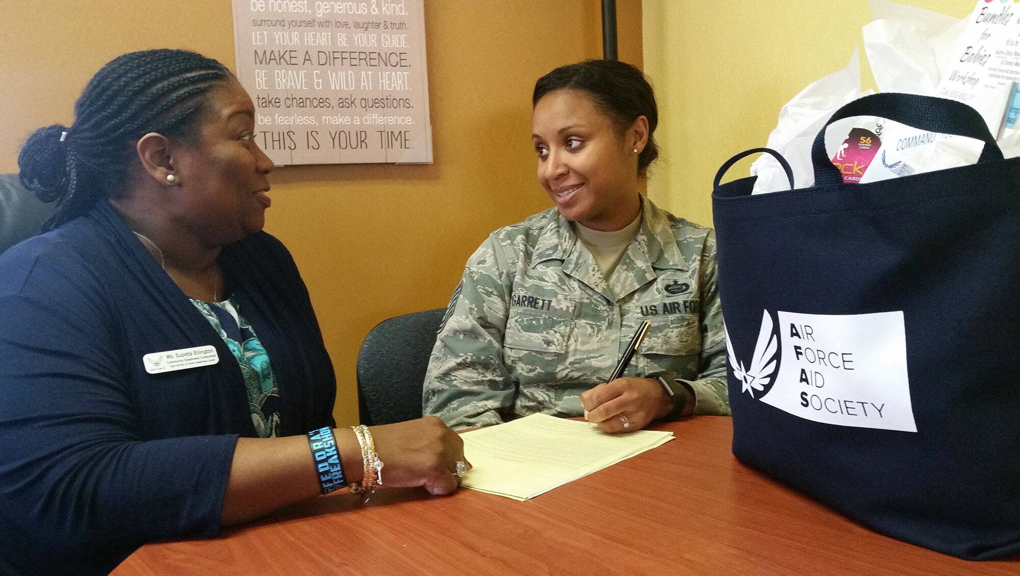 Tech. Sgt. Joy Garrett, 96th Force Support Squadron, fills out paperwork for Air Force Aid Society assistance as Suzette Ellington, AFAS officer, looks on.  The Air Force Aid Society’s 75th anniversary was March 9.  (U.S. Air Force photo/Kevin Gaddie)   