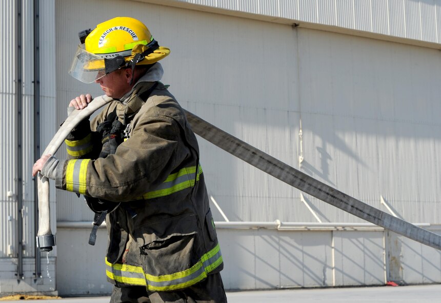 Tim McCartney North Lemmon fire department firefighter, rolls up a fire hose at Minot Air Force Base, N.D., Feb. 24, 2017.  The 5th Civil Engineer firefighters hosted missile field response training for several local fire departments. (U.S. Air Force photo/Staff Sgt. Chad Trujillo)