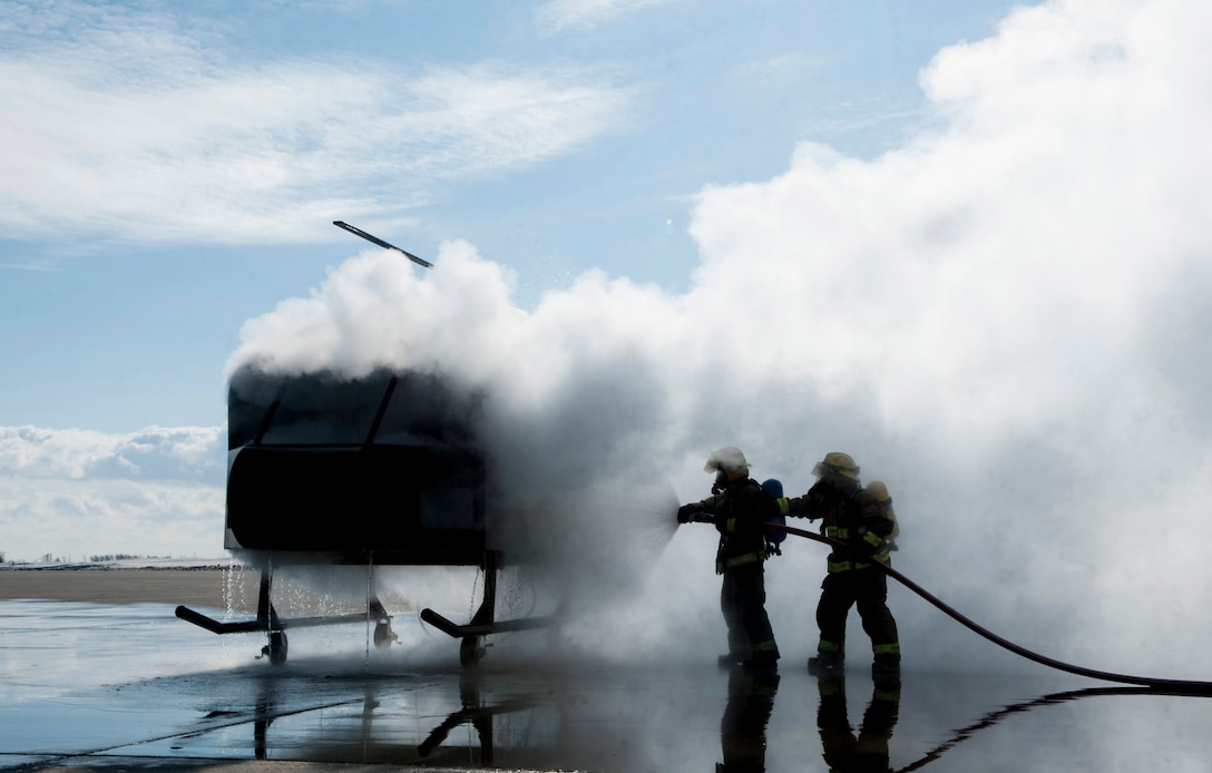 Firefighters extinguish a flaming mobile trainer at Minot Air Force Base, N.D., Feb. 24, 2017. The 5th Civil Engineer fire department invited several local fire departments for missile field response training. (U.S. Air Force photo/Airman 1st Class Jonathan McElderry)