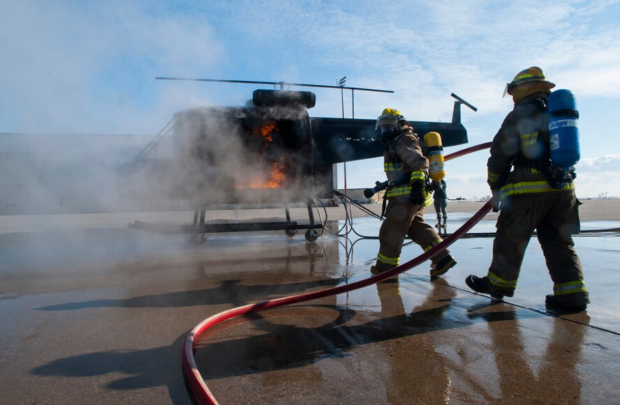 (From left) Dustin Bazille, Kenmare Fire Department firefighter, and Tim McCartney, North Lemmon Fire Department firefighter, extinguish a burning mobile trainer at Minot Air Force Base, N.D., Feb. 24, 2017. The Minot AFB 5th Civil Engineer Squadron hosted a North Dakota Fire Association training class for mutual aid fire departments. (U.S. Air Force photo/Airman 1st Class Jonathan McElderry)