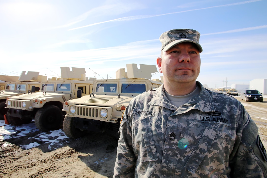 Sgt. 1st Class Jaime Herrera with the 181st Multi-Functional Training Brigade stops for a photo March 3, 2017, by military vehicle to be used for the Operation Cold Steel exercise at Fort McCoy. Herrera has been nominated for the Soldier’s Medal for actions he completed during an ice rescue at Wisconsin’s Mirror Lake State Park in January. 