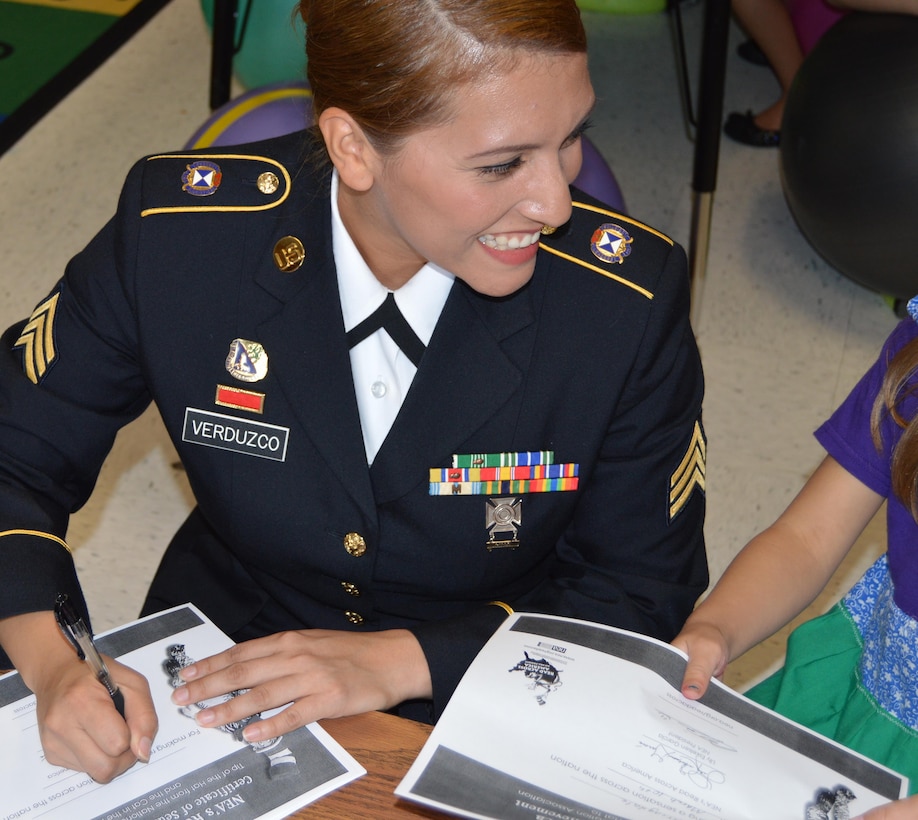 U.S. Army Reserve Sgt. Ana Verduzco with the 4th Sustainment Command (Expeditionary) hands out Read Across America certificates to students at Kinder Ranch Elementary in San Antonio, TX, Mar. 10, 2017. 