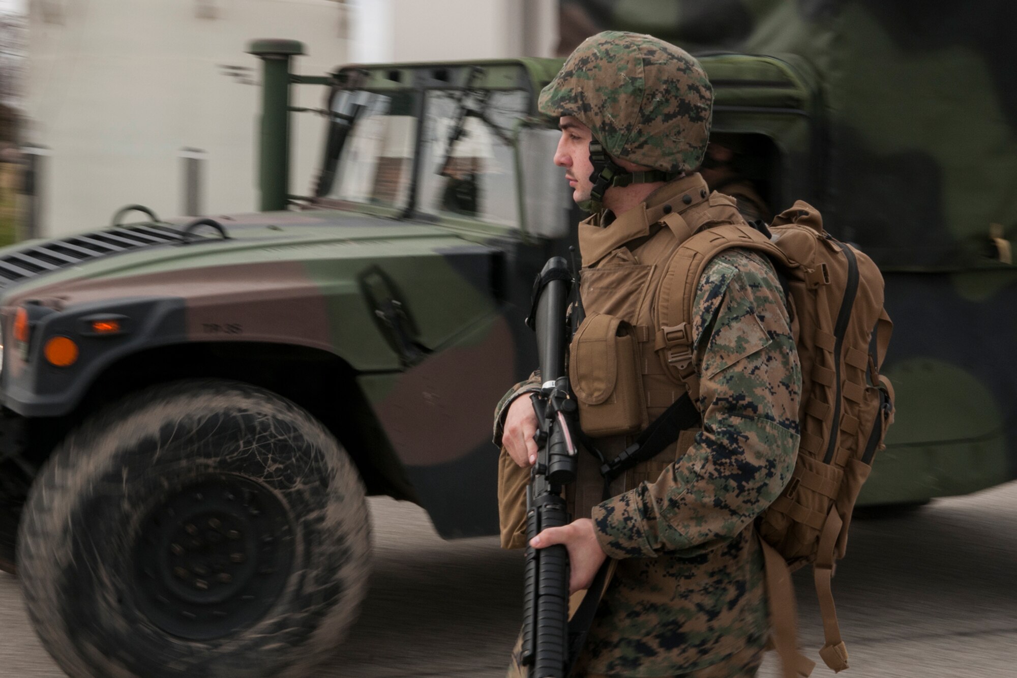 Lance Cpl. Matt Moats, Detachment 1, Communications Company, 4th Marine Logistics Group field wireman, walks alongside a transport vehicle during a simulated patrol at Grissom Air Reserve Base, Ind. on March 9, 2017. The Marines ran the patrol as part of a weeklong training exercise. (U.S. Air Force photo/Staff Sgt. Dakota Bergl)