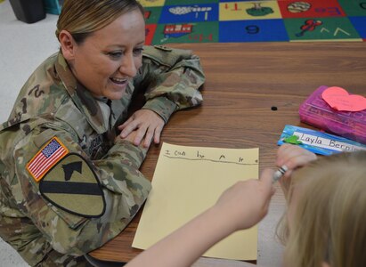 U.S. Army Reserve Master Sgt. Johnnie Garcia with the 4th Sustainment Command (Expeditionary) talks with a student at Kinder Ranch Elementary in San Antonio, TX, about her definition of “hero” on Mar. 10, 2017. 