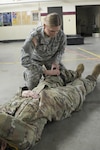 Spc. Amanda Huenink, a medic with 135th Medical Company, applies a tourniquet to another Soldier during medical training at the unit’s armory in Waukesha, Wis., March 5, 2017. In her civilian job as a dispatcher, she helped a frantic father deliver his fast-arriving son,