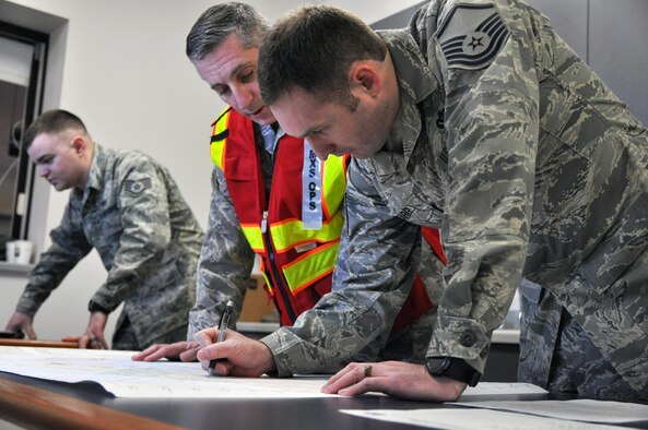 Members of the Emergency Management team look over a base map during a table top exercise held on March, 4, 2017 by the Emergency Operations Center here. EM holds regular exercises and scenarios to ensure and improve readiness among base personnel. (U.S. Air Force photo/Senior Airman Joshua Kincaid)