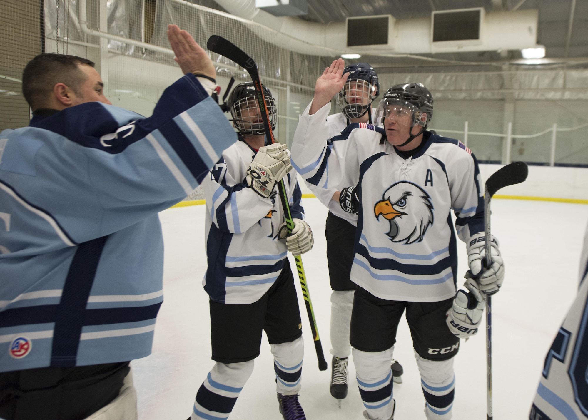 Dover Eagles Goalie Jeff Kach and forward Donny Mahaux, high-five to celebrate their team’s 6-4 victory against the Fraternal Order of Police Lodge 15 hockey team March 11, 2017, at the Centre Ice Rink in Harrington, Del. In total, $2,800 was raised for the family of Correctional Officer Lt. Steven Floyd, who was killed in the line of duty. (U.S. Air Force photo by Senior Airman Zachary Cacicia)