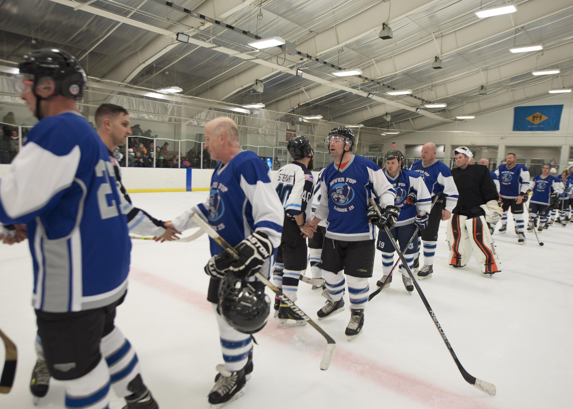 The Dover Eagles and Fraternal Order of Police Lodge 15 hockey players shake hands at the conclusion of a charity game March 11, 2017, at the Centre Ice Rink in Harrington, Del. The Eagles were shutout in the first period, down 2-0, but came back to win the game 6-4. (U.S. Air Force photo by Senior Airman Zachary Cacicia)