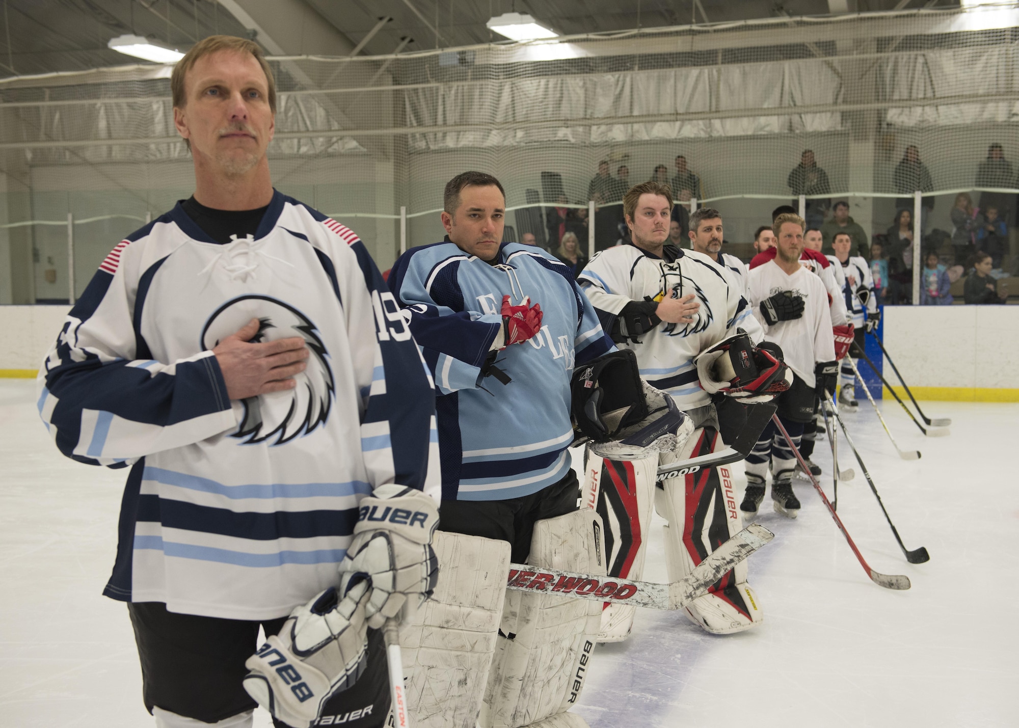 The Dover Eagles hockey team stands at center ice during the playing of the national anthem prior to the start of charity hockey game March 11, 2017, at the Centre Ice Rink in Harrington, Del. The Eagles were pitted against the Fraternal Order of Police Lodge 15 hockey team. (U.S. Air Force photo by Senior Airman Zachary Cacicia)