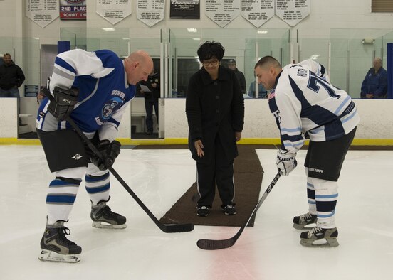 Saundra Floyd, widow of Lt. Steven Floyd, drops the ceremonial first puck to David Gist, Fraternal Order of Police Lodge 15 defenseman, and Mike Roth, Dover Eagles center, March 11, 2017, at the Centre Ice Rink in Harrington, Del. Correctional Officer Lt. Steven Floyd was killed in the line of duty. (U.S. Air Force photo by Senior Airman Zachary Cacicia)