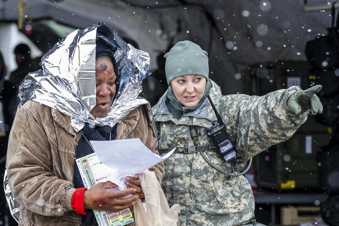 South Carolina Army National Guard 2nd Lt. Nikki Hooks, an ambulance platoon leader, assists a simulated patient during a U.S. Army North joint training exercise in Owings Mills, Md., March 10, 2017. Air National Guard photo by Tech. Sgt. Jorge Intriago