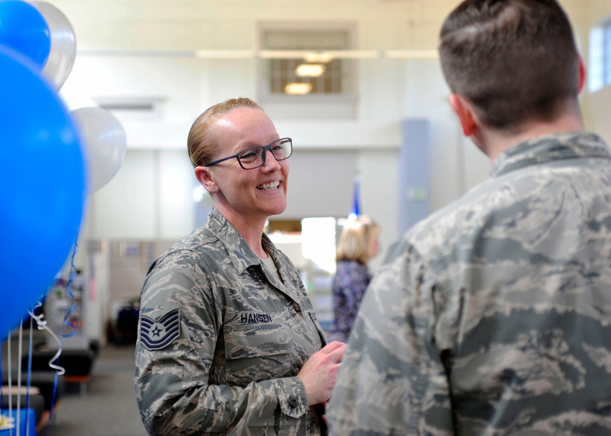 Tech. Sgt. Nalopa Hansen, 627th Force Support Squadron Air Force Aid Society assistant officer, smiles while speaking to a fellow Airman during the AFAS 75th Anniversary Celebration, March 10, 2017 at the Military Personnel Section on McChord Field, Wash. As their website proudly proclaims, for every dollar donated, AFAS pledges to provide three dollars to Airmen in need. (U.S. Air Force photo/Staff Sgt. Whitney Amstutz)