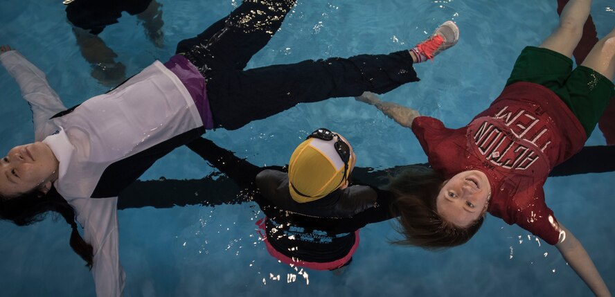 A Uitemate instructor holds Shumi Kaufman (left), 35th Force Support Squadron intercultural program coordinator and Airman 1st Class Sarah Rose (right), 35th Maintenance Squadron aircraft electrical and environmental systems technician in the base pool at Misawa Air Base, Japan, March 12, 2017. Rose expressed wanting to teach others about Uitemate so they are prepared in case an event like 3/11 ever happens again. (U.S. Air Force photo by Tech Sgt. Araceli Alarcon)