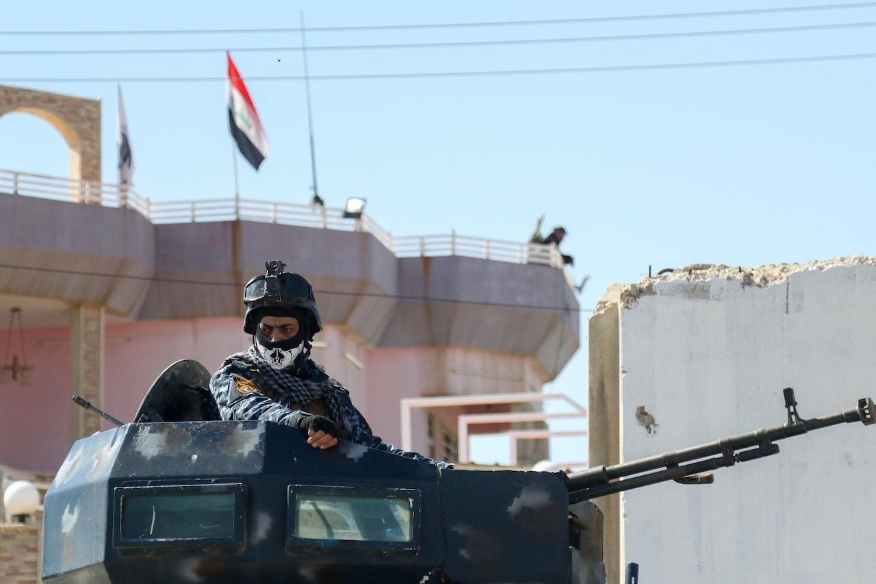 An Iraqi federal police member, supported by Combined Joint Task Force-Operation Inherent Resolve, guard Abu Saif, Iraq from a vehicle turret, during the effort to liberate and secure West Mosul, Iraq, March 6, 2017. CJTF-OIR is the global Coalition to defeat ISIS in Iraq and Syria. (U.S. Army photo by Staff Sgt. Jason Hull)