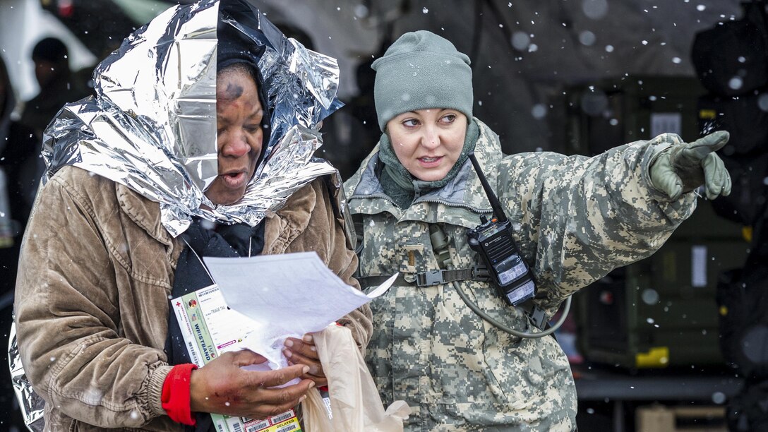 South Carolina Army National Guard 2nd Lt. Nikki Hooks, an ambulance platoon leader, assists a simulated patient during a U.S. Army North joint training exercise in Owings Mills, Md., March 10, 2017. Air National Guard photo by Tech. Sgt. Jorge Intriago