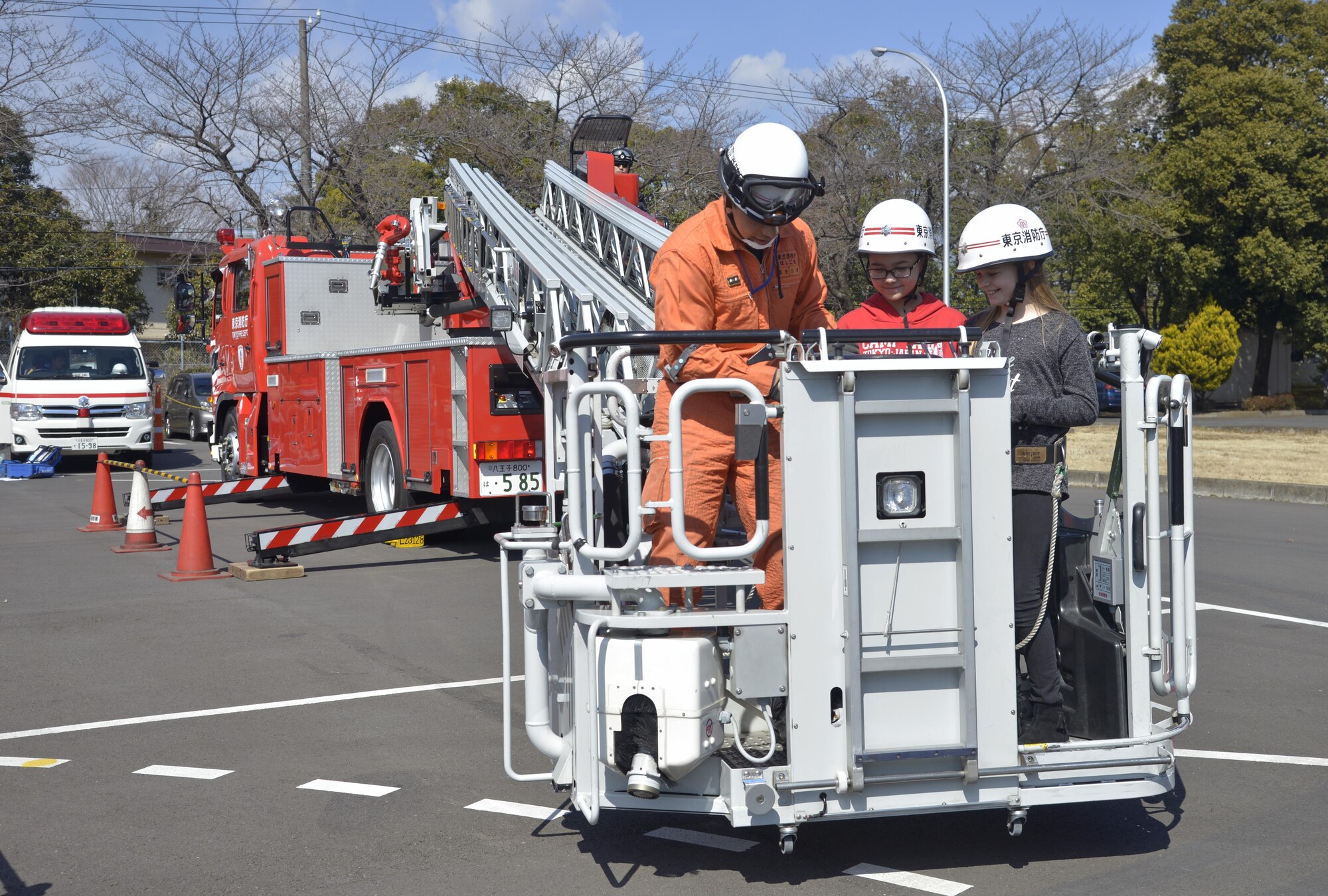 A member of the Tokyo Fire Department shows Yokota West Elementary School students what it’s like to be in a ladder basket during the Yokota Safety and Readiness Festival at Yokota Air Base, Japan, March 10, 2017. The event allowed Yokota personnel to have fun while learning how to safely handle situations that could take place in their daily lives. (U.S. Air Force photo by Staff Sgt. David Owsianka)