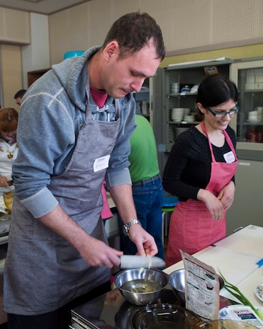 Dimitri Jelobkovitch, a participant in the cooking class, slices vegetables during a cultural exchange at Tsuzu Elementary School at Iwakuni City, Japan, March 11, 2017. During the event, a traditional tea ceremony was demonstrated and a cooking class was held to teach people how to make common Japanese dishes. The event, which brought Americans and Japanese together, taught residents from MCAS Iwakuni about Japanese culture. (U.S. Marine Corps photo by Lance Cpl. Gabriela Garcia-Herrera)
