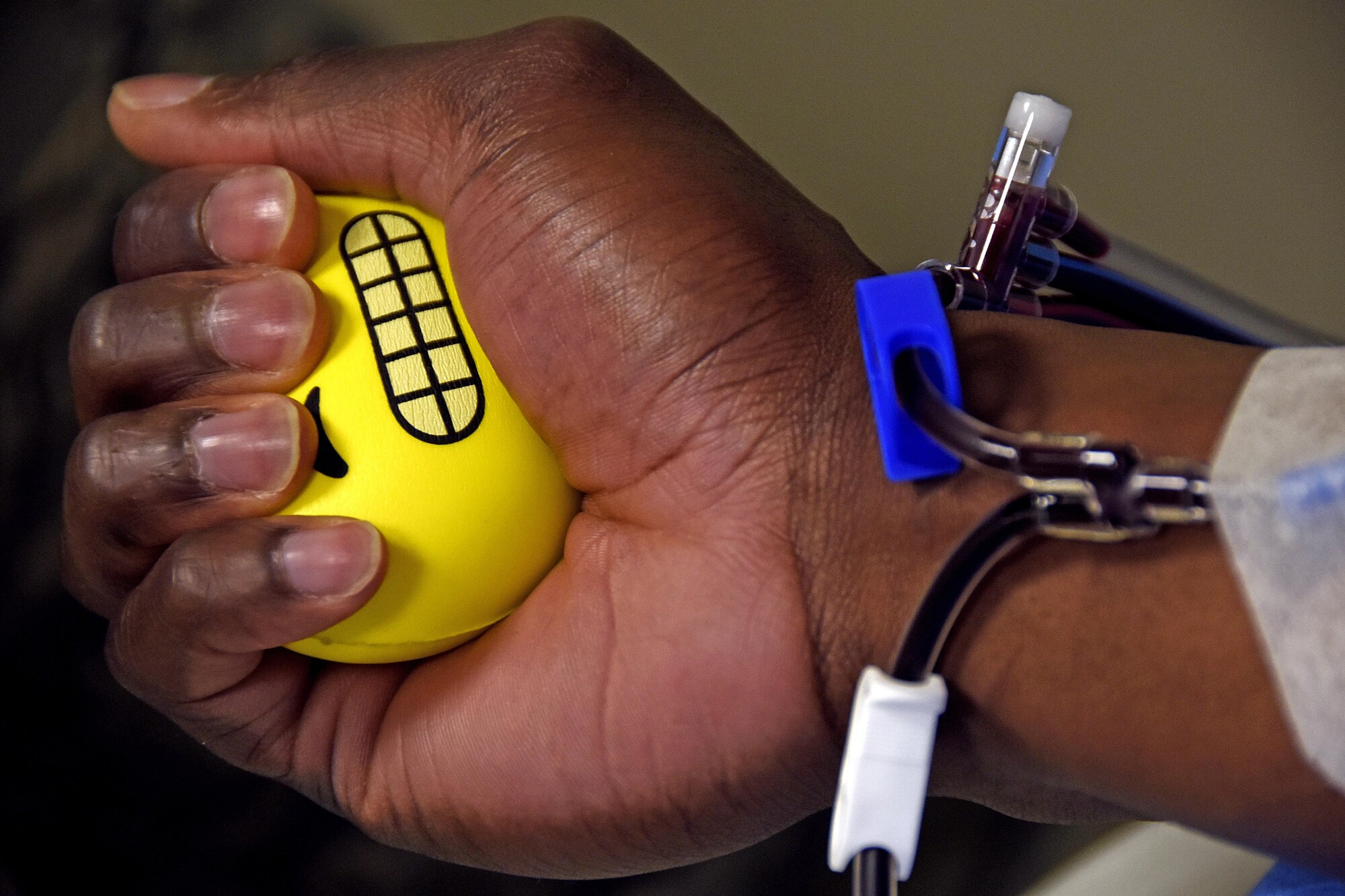 Senior Airman Jordan Marshall, an aerospace medical technician with the 379th Expeditionary Medical Group, squeezes a stress ball during a blood platelet donation at Al Udeid Air Base, Qatar, March 7, 2017. Apheresis element Airmen at Al Udeid AB are tasked with collecting and storing platelet products and providing them for distribution throughout the U.S. Central Command area of responsibility. (U.S. Air Force photo by Senior Airman Cynthia A. Innocenti)