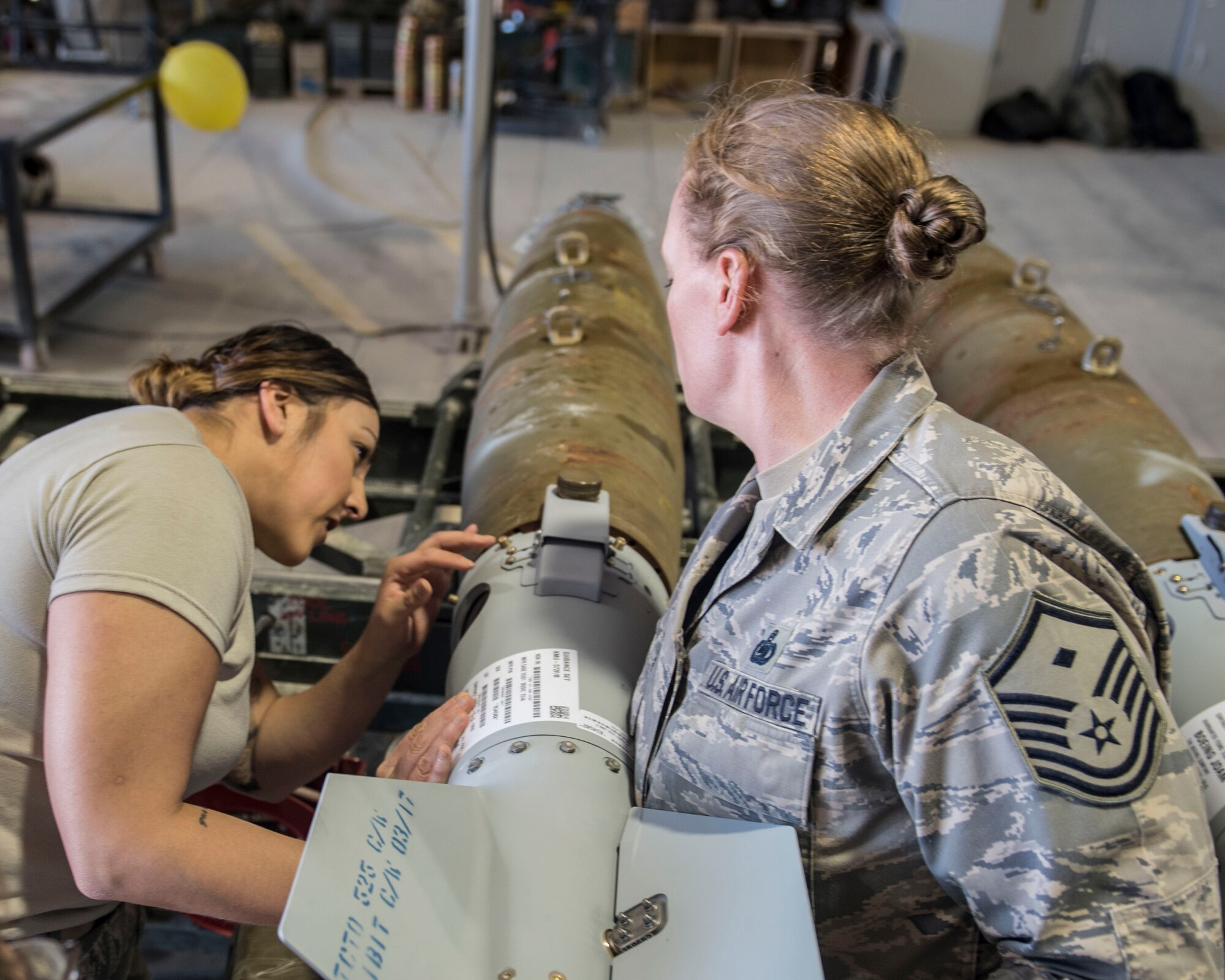 Staff Sgt. Elizabeth Silva, 332nd Air Expeditionary Wing command chief executive assistant, and Master Sgt. Victoria Kenny, 332nd Expeditionary Civil Engineer Squadron first sergeant, connect the tail of a GBU-38 Mar. 7, 2017, in Southwest Asia. (U.S. Air Force photo by Staff Sgt. Eboni Reams)