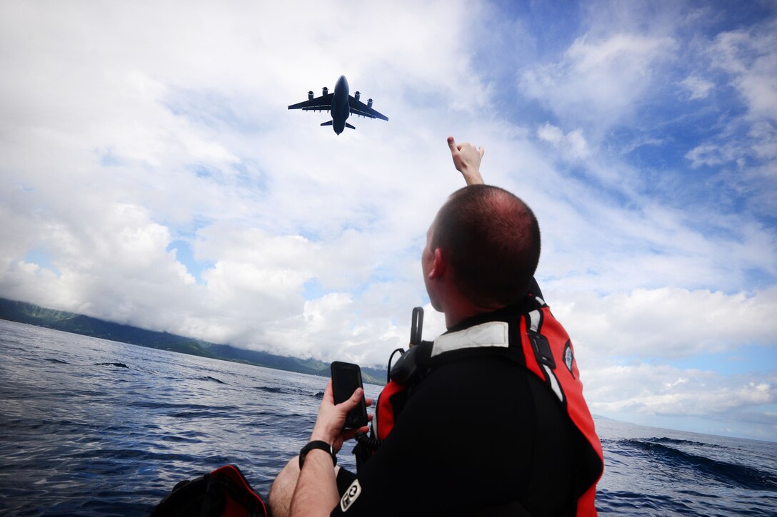 A New York Air National Guardsman signals a low flying C-17 Globemaster during joint training with Human Space Flight Support Detachment 3, near Marine Corps Base Hawaii, March 5 2017. The guardsman is a pararescueman assigned to the 103rd Rescue Squadron. Air National Guard photo by Staff Sgt. Christopher Muncy
