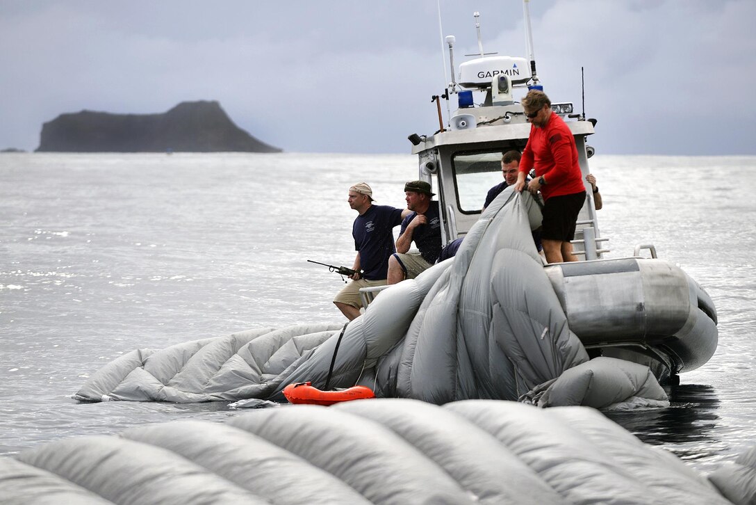 New York Air National Guardsmen recover chutes and gear after a jump from a C-17 Globemaster and landing in the water during joint training with Human Space Flight Support Detachment 3, near Marine Corps Base Hawaii, March 5, 2017. Air National Guard photo by Staff Sgt. Christopher Muncy
