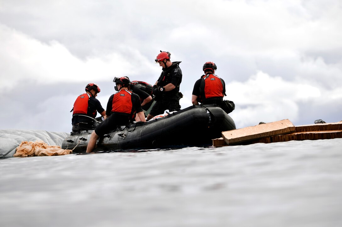 New York Air National Guardsmen climb into a boat after jumping from a C-17 Globemaster into the water during joint training with Human Space Flight Support Detachment 3, near Marine Corps Base Hawaii, March 5, 2017. Air National Guard photo by Staff Sgt. Christopher Muncy



