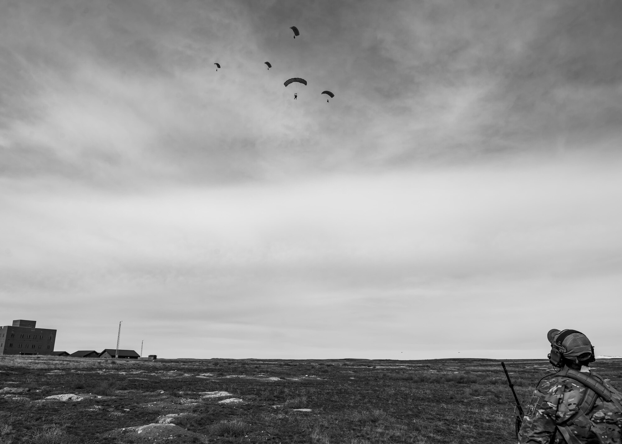 Tech. Sgt. Ben Domain, a Survival, Evasion, Resistance, and Escape (SERE) specialists with the 308th Rescue Squadron, watches pararescuemen and a combat rescue officer glide-down to a simulated hostile village to rescue a patient, March 2, 2017, at the Orchard Combat Training Center in Idaho, during pre-deployment training for the 305th Rescue Squadron. The 305th RQS, located at Davis-Monthan Air Force Base, Ariz., is conducting training at the Idaho Air National Guard’s Orchard Combat Training Center, a 143,000-acre live-fire range located south of Boise, Idaho, to hone all of their search and rescue procedures before heading to Southwest Asia. (U.S. Air Force photo/Staff Sgt. Jared Trimarchi)