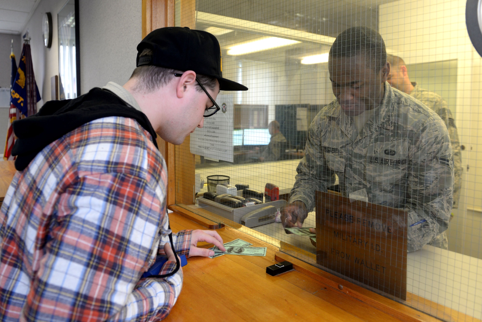 U.S. Air Force Senior Airman Ryan Hanlon, 100th Security Forces Squadron electronic security system manager, simulates robbing the 100th Comptroller Squadron cash cage from U.S. Air Force Airman 1st Class Shaquille Simister, 100th CPTS financial services apprentice, March 13, 2017, on RAF Mildenhall, England. The simulated armed robbery was part of an exercise to test 100th CPTS Airmen under pressure and ensure they’re ready in case of a real-world incident. (U.S. Air Force photo by Staff Sgt. Kate Thornton)