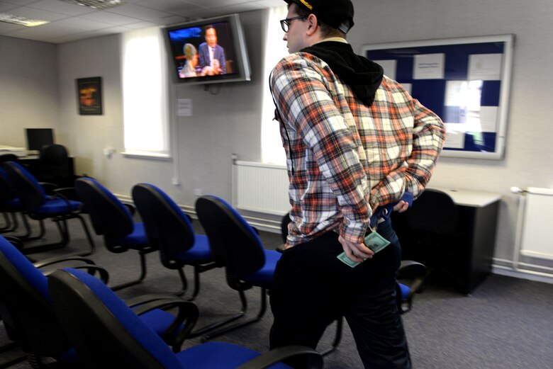 U.S. Air Force Senior Airman Ryan Hanlon, 100th Security Forces Squadron electronic security system manager, simulates robbing the 100th Comptroller Squadron cash cage March 13, 2017, on RAF Mildenhall, England. The simulated armed robbery was part of an exercise to test 100th CPTS Airmen under pressure and ensure they’re ready in case of a real-world incident. (U.S. Air Force photo by Staff Sgt. Kate Thornton)