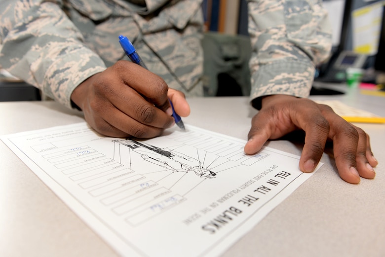 U.S. Air Force Airman 1st Class Shaquille Simister, 100th Comptroller Squadron financial services apprentice, fills out an identification card during a simulated robbery March 13, 2017, on RAF Mildenhall, England. The simulated armed robbery was part of an exercise to test 100th CPTS Airmen under pressure and ensure they’re ready in case of a real-world incident. (U.S. Air Force photo by Staff Sgt. Kate Thornton)