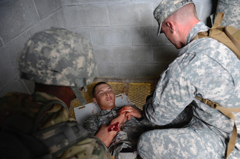 U.S. Army Staff Sgt. Mathew Johnson, Charlie Company, 210th Aviation Regiment, 128th Aviation Brigade instructor and NCO of the Year competitor performs first aid on a simulated Soldier’s injuries during the NCO and Advanced Individual Training Platoon Sergeant of the Year Competition at Joint Base Langley-Eustis, Va., March 8, 2017. Along with demonstrating leadership abilities in a simulated hostile environment, competitors had to clear buildings and identify improvised explosive devices during the battlefield scenario. (U.S. Air Force photo/Airman 1st Class Kaylee Dubois)