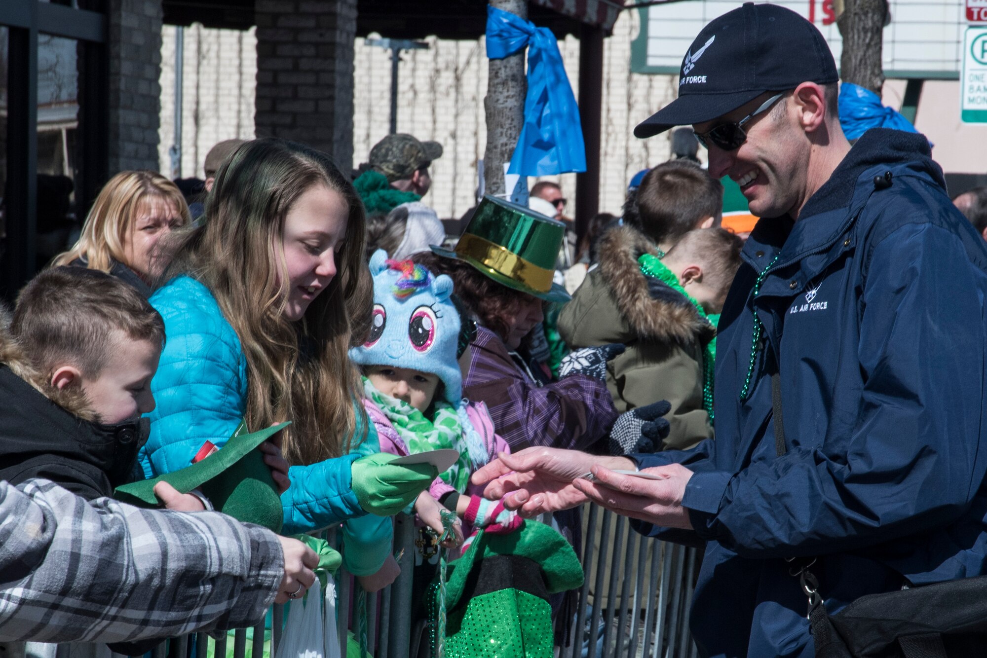 Col. E. John Teichert, 11th Wing and Joint Base Andrews commander, hands out Air Force lanyards, pins and stickers during the South Side St. Patrick’s Day Parade in Chicago, March 12, 2017. Teichert accompanied the honor guard with Chief Master Sgt. Nathaniel M. Perry Jr., 11th Wing and JBA command chief master sergeant. The 11th Wing serves as a host unit for the honor guard and U.S. Air Force Band, both of which are based out of Joint Base Anacostia-Bolling, District of Colombia. (U.S. Air Force photo by Senior Airman Jordyn Fetter)