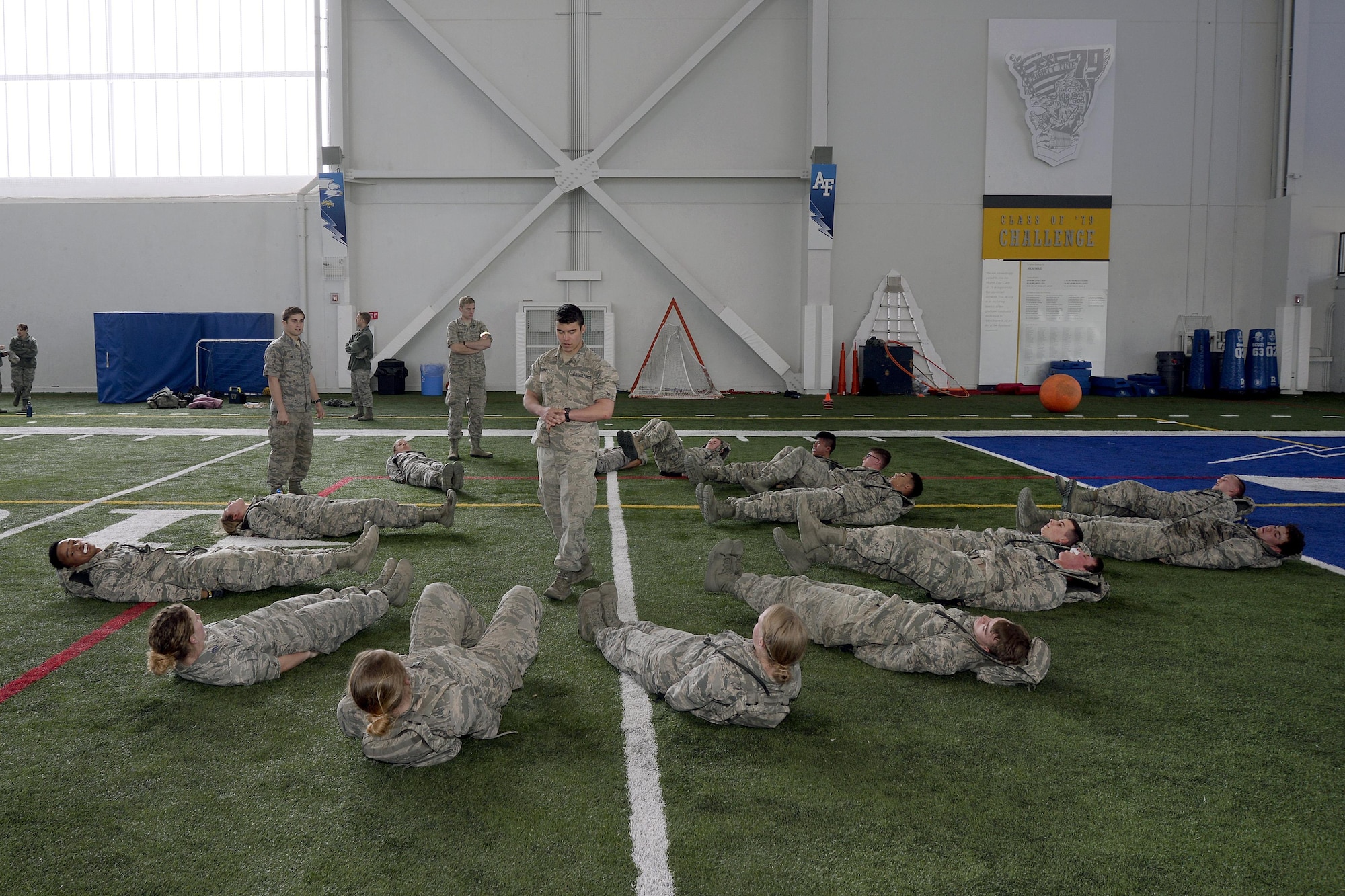 A senior cadets leads freshmen cadets through flutter kicks March 10, 2017 at the U.S. Air Force Academy, Colorado, during Recognition. Recognition is a rigorous annual event freshmen or "four degrees" must overcome before earning the status of "recognized cadet." (U.S. Air Force photo/Jason Gutierrez)   