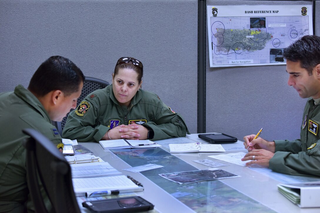 Puerto Rico Air National Guard Maj. Isbelia Reyes, center, an aircraft commander assigned to the 156th Airlift Wing, briefs Capts. Jesuan Aviles, left, and Mario Ibarra before participating in a mission to commemorate International Women's Day at Muñiz Air National Guard Base, Puerto Rico, March 8, 2017. Aviles is a navigator and Ibarra is a pilot assigned to the wing. Air National Guard photo by Staff Sgt. Angel Oquendo