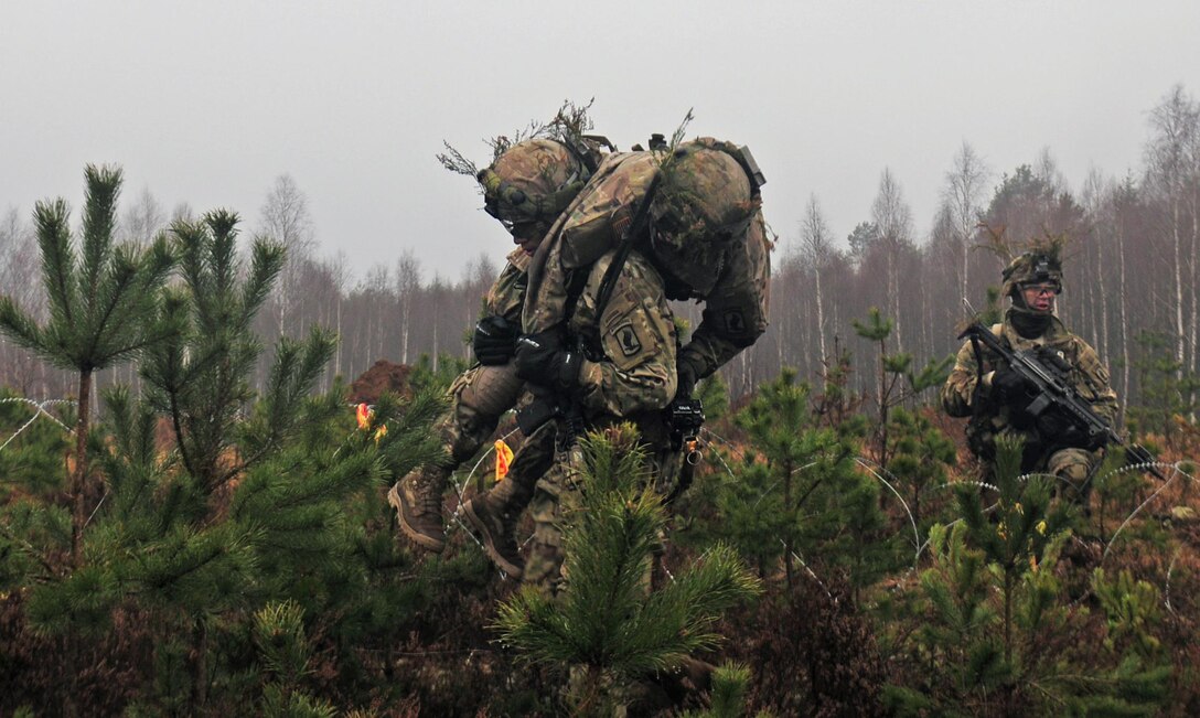 A soldier from Able Company, 2nd Battalion, 503rd Infantry Regiment, carries a “wounded” comrade off the battlefield during Iron Sword 2016 in Pabrade, Lithuania, Nov. 24, 2016. The exercise is designed to promote regional stability and security while strengthening partner capacity. Army photo by Staff Sgt. Corinna Baltos